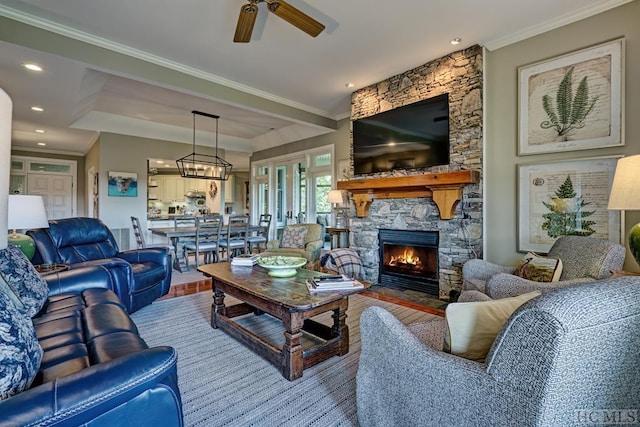 living room featuring a fireplace, ceiling fan, and crown molding