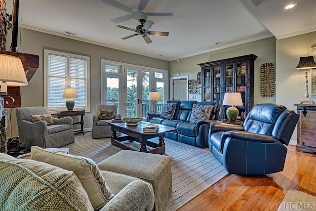 living room with ornamental molding, french doors, and light wood-type flooring