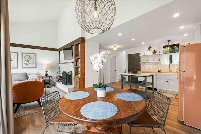 38 Lonely Mountain Dr Unit 24C, Sapphire, NC 28774 - dining area with light wood finished floors, a high ceiling, recessed lighting, and a multi sided fireplace