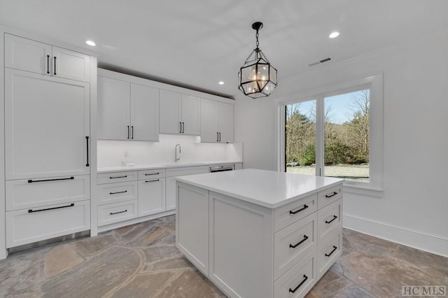 kitchen with white cabinetry, a center island, sink, and pendant lighting