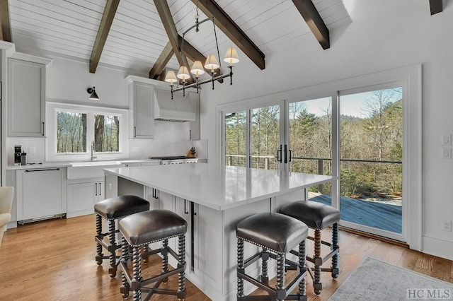 kitchen with beamed ceiling, a kitchen breakfast bar, and dishwasher