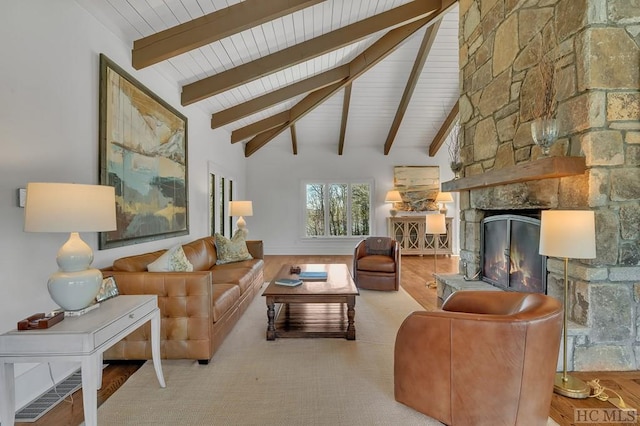 living room featuring a stone fireplace and vaulted ceiling with beams