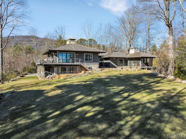 back of house with a wooden deck and a lawn