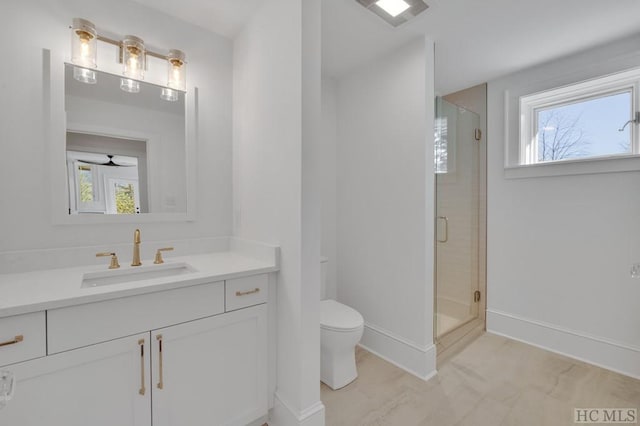 bathroom with ceiling fan, vanity, toilet, and an enclosed shower