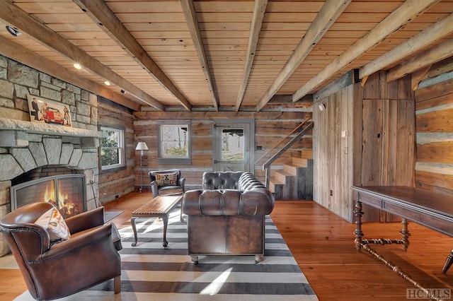 living room featuring beamed ceiling, wooden ceiling, and wooden walls