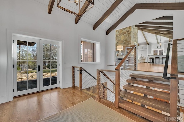 stairway featuring beamed ceiling, high vaulted ceiling, and hardwood / wood-style floors