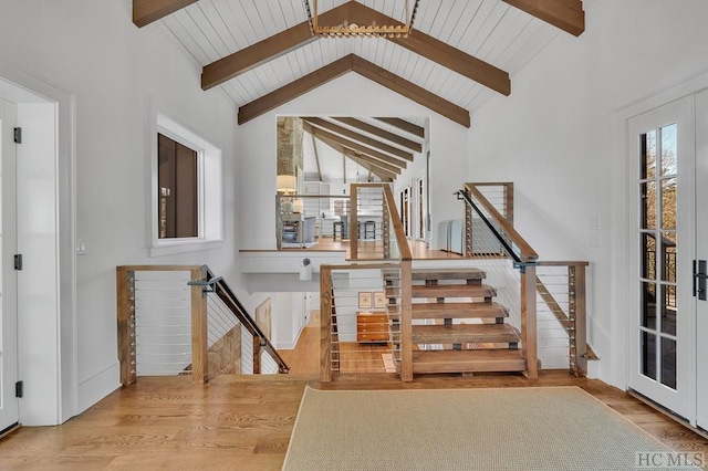 staircase featuring french doors, vaulted ceiling with beams, and wood-type flooring