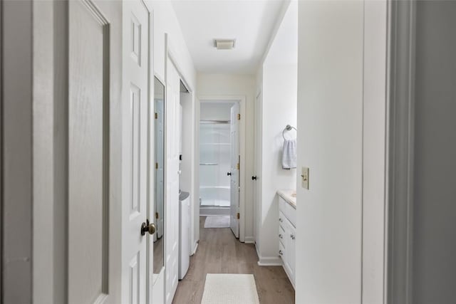 bathroom with a shower, vanity, visible vents, and wood finished floors
