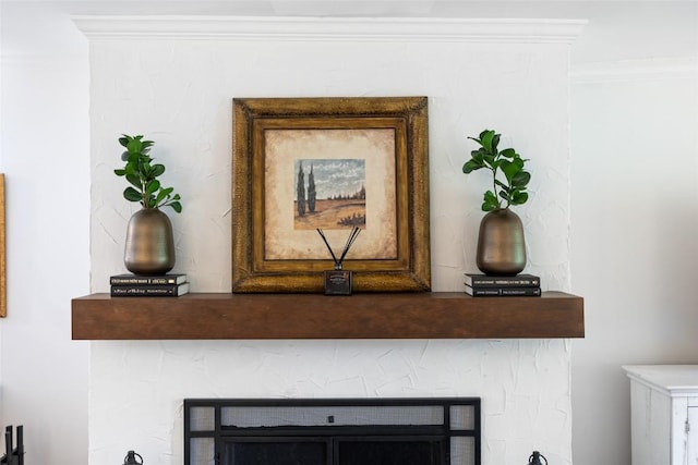 interior details with a fireplace and crown molding