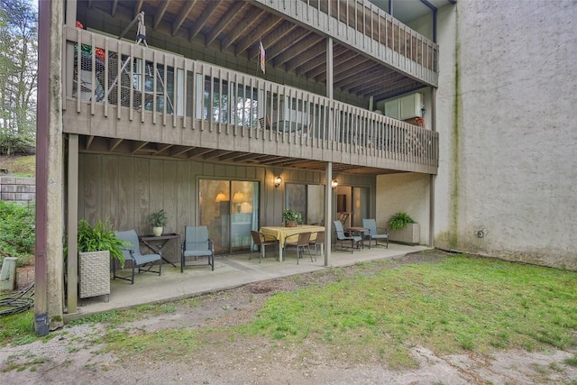 rear view of property featuring a balcony and a patio area