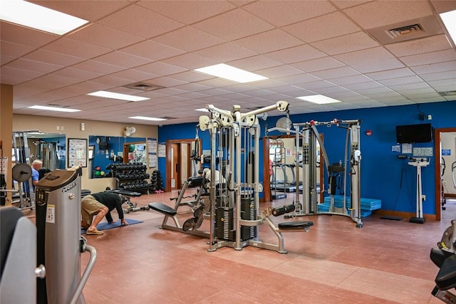exercise room with a paneled ceiling and visible vents