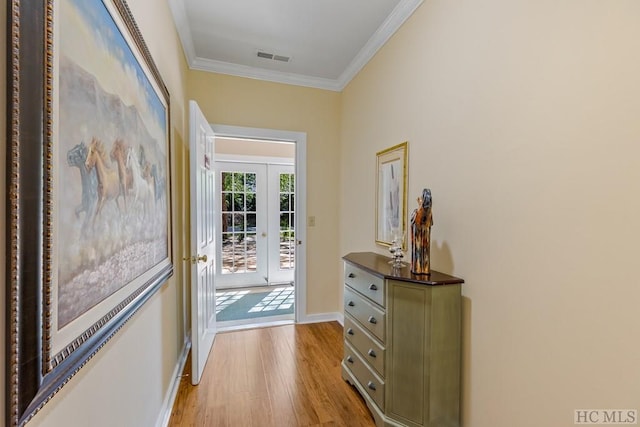 doorway with french doors, ornamental molding, and light hardwood / wood-style floors