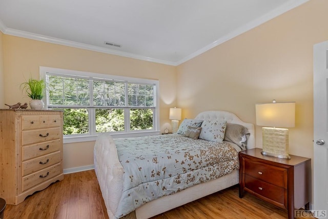 bedroom with crown molding and wood-type flooring