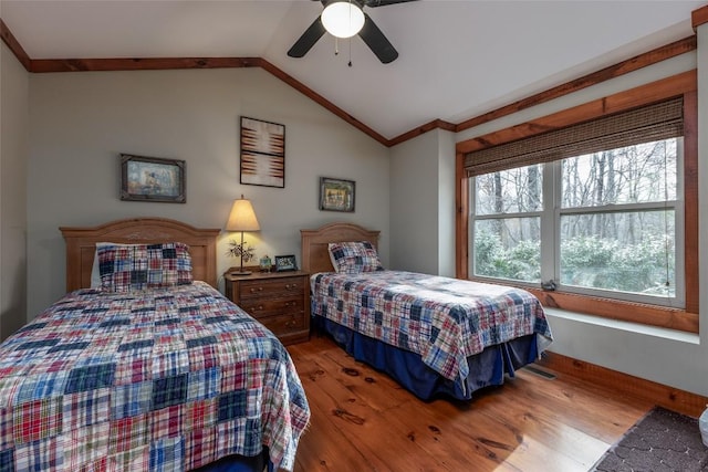 bedroom featuring lofted ceiling, a ceiling fan, ornamental molding, and wood finished floors