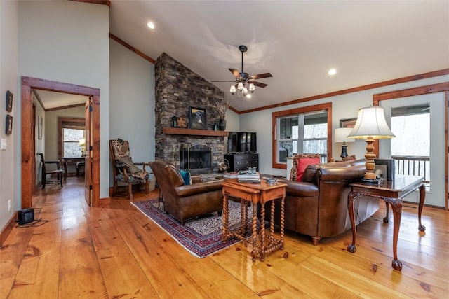 living area featuring baseboards, a ceiling fan, light wood-style flooring, crown molding, and a fireplace