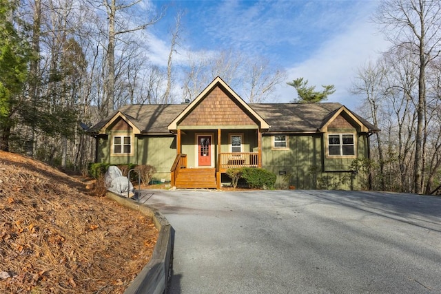 view of front of house with aphalt driveway, crawl space, and a porch