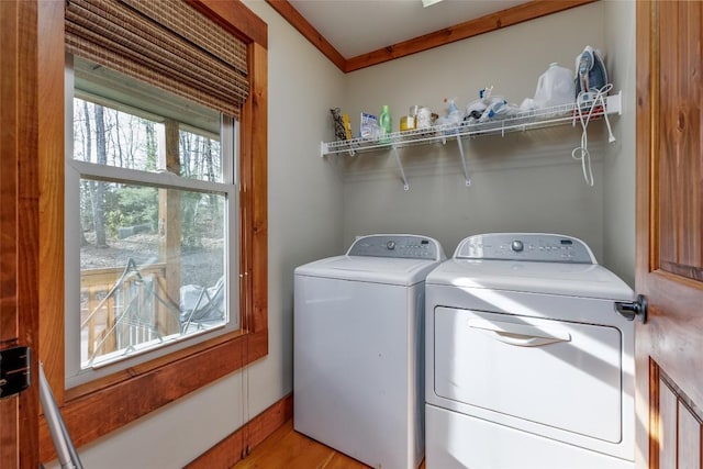 clothes washing area with laundry area, light wood-style flooring, and washer and dryer