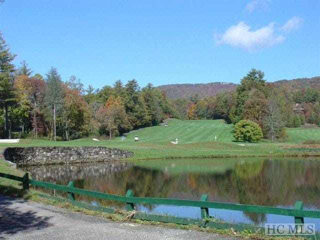 view of community featuring a water view and fence