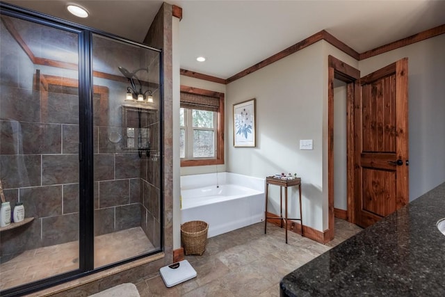 full bathroom featuring vanity, a shower stall, a bath, and baseboards