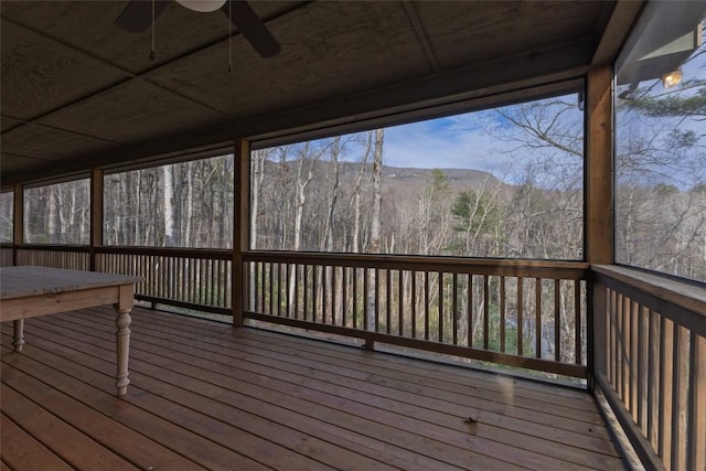 deck featuring ceiling fan and a forest view