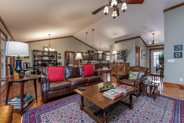 living area featuring ceiling fan with notable chandelier, vaulted ceiling, baseboards, and wood finished floors