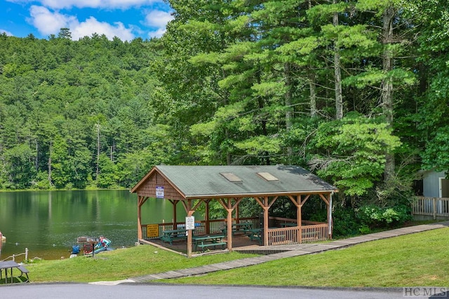 view of property's community with a water view, a gazebo, and a lawn