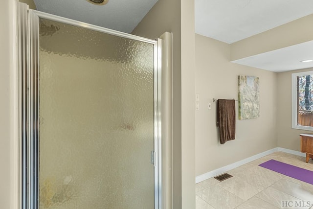 bathroom with walk in shower and tile patterned flooring