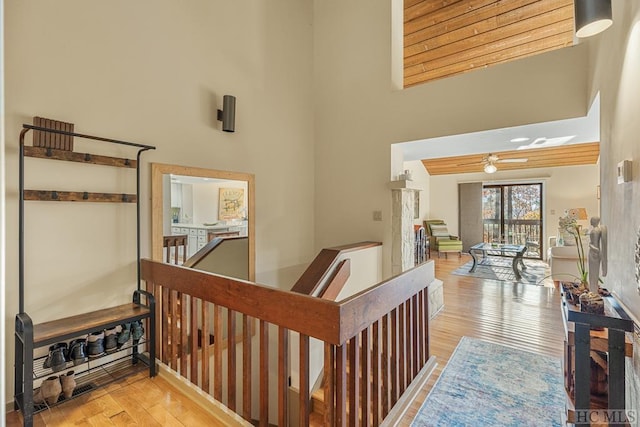 corridor featuring a towering ceiling and light hardwood / wood-style floors