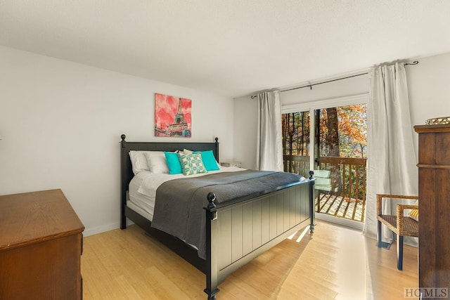 bedroom with access to exterior and light hardwood / wood-style floors