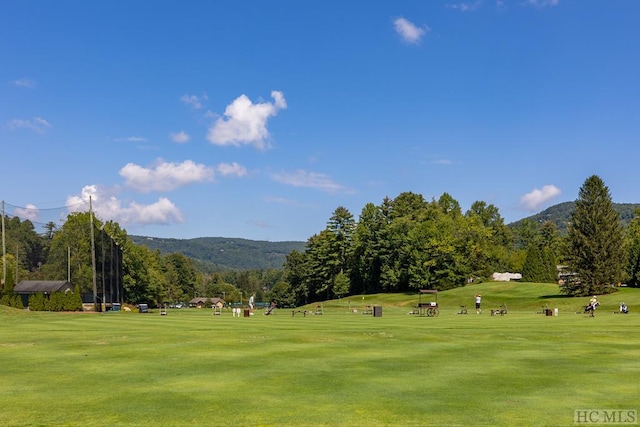 surrounding community featuring a mountain view and a lawn