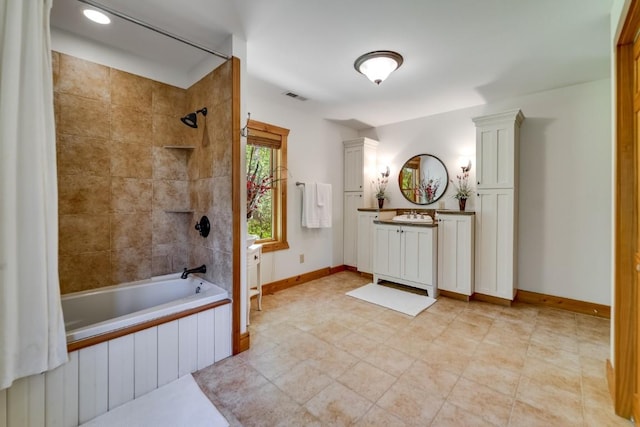full bath with tiled shower / bath, vanity, and baseboards
