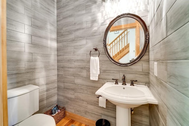 bathroom featuring tile walls and toilet