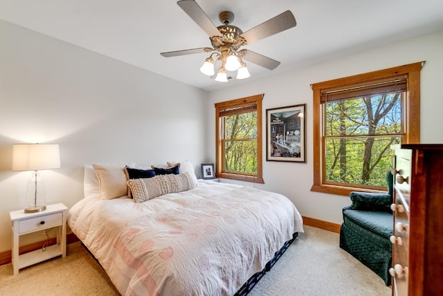 bedroom with light colored carpet, multiple windows, and baseboards