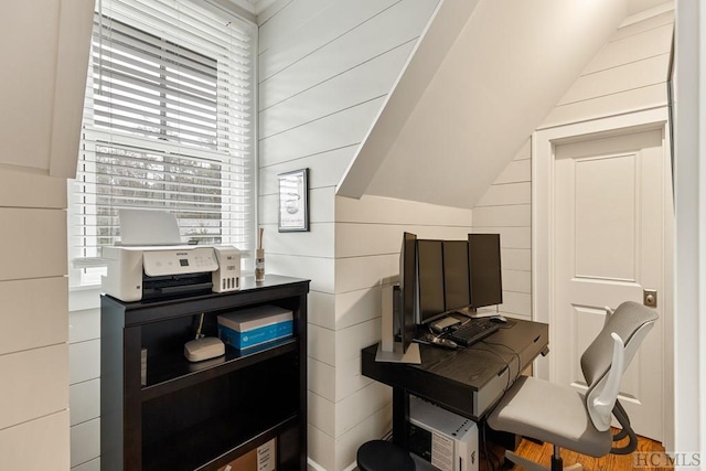 office area featuring lofted ceiling and wooden walls