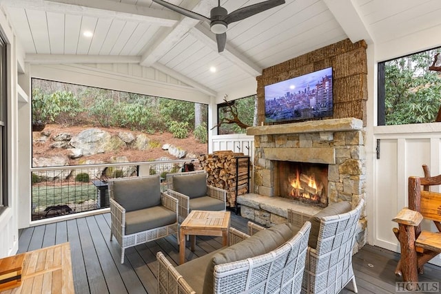 sunroom / solarium with lofted ceiling with beams, a stone fireplace, and ceiling fan