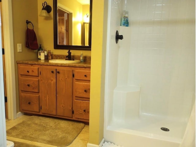 bathroom featuring tile patterned flooring, a shower, and vanity