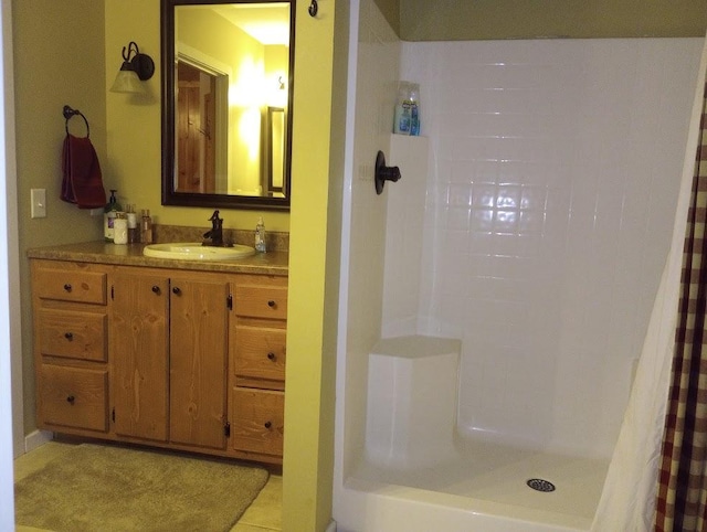 bathroom featuring tile patterned flooring, vanity, and walk in shower