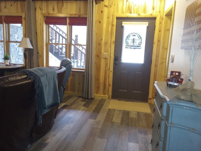 foyer entrance featuring dark hardwood / wood-style floors and wood walls