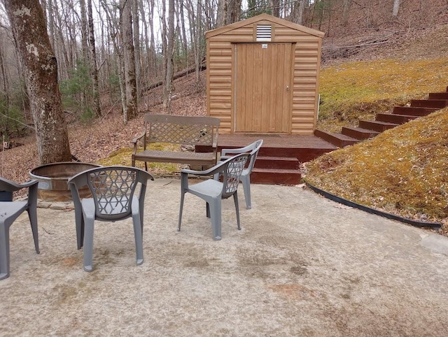 view of patio with a storage shed and a fire pit