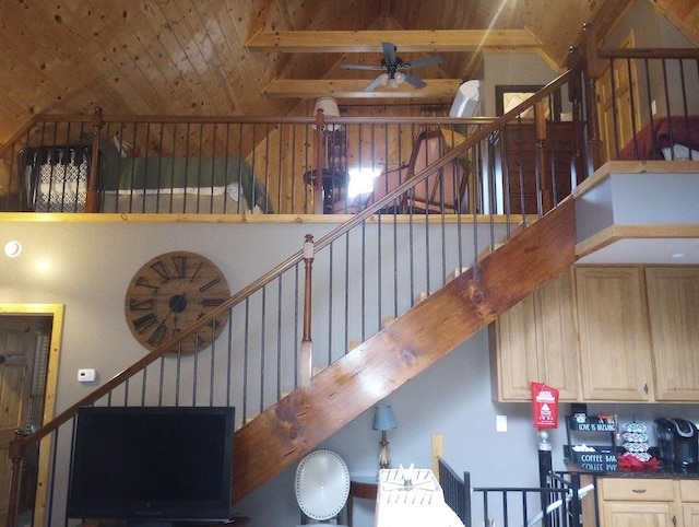 staircase with beam ceiling, high vaulted ceiling, wooden ceiling, and ceiling fan