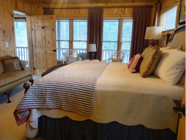 bedroom with carpet floors and wooden walls