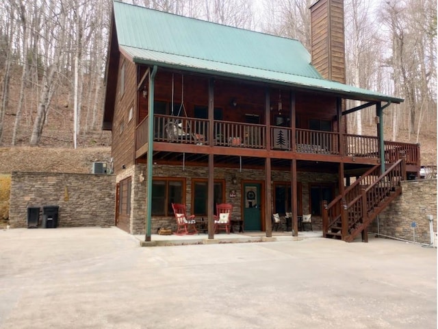 rear view of property with central AC