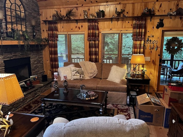 living room featuring a healthy amount of sunlight, a fireplace, hardwood / wood-style floors, and wood walls