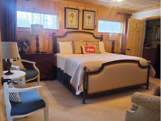 carpeted bedroom with wooden ceiling and wooden walls