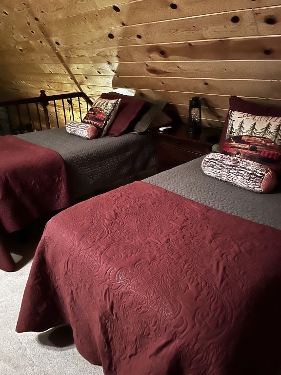 carpeted bedroom featuring wooden walls