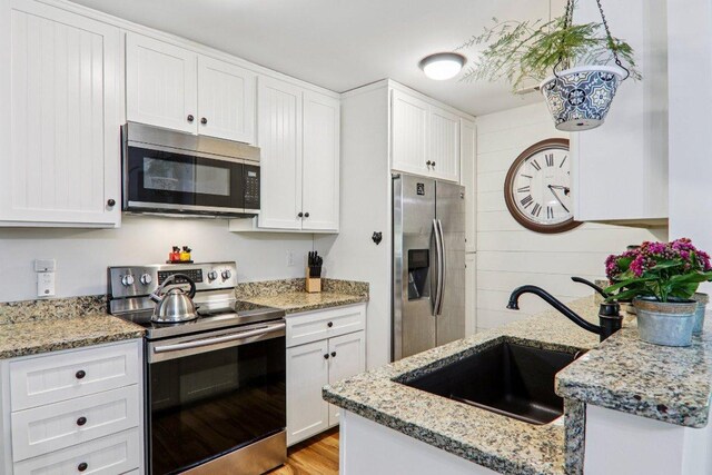 98 Dogwood Knob Ln Unit 3A, Sapphire, NC 28774 - kitchen featuring stainless steel appliances, white cabinetry, light stone counters, and light wood-style floors
