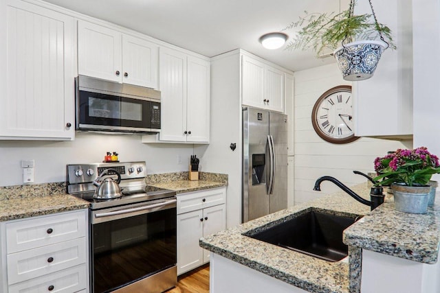 98 Dogwood Knob Ln Unit 3A, Sapphire, NC 28774 - kitchen featuring stainless steel appliances, white cabinetry, light stone counters, and light wood-style floors