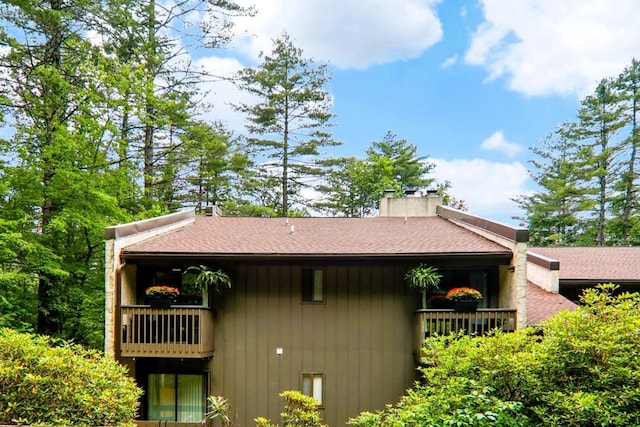 98 Dogwood Knob Ln Unit 3A, Sapphire, NC 28774 - view of property exterior featuring roof with shingles, a balcony, and a chimney