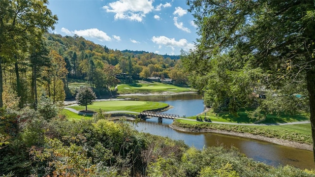 surrounding community with a water view, a wooded view, and golf course view