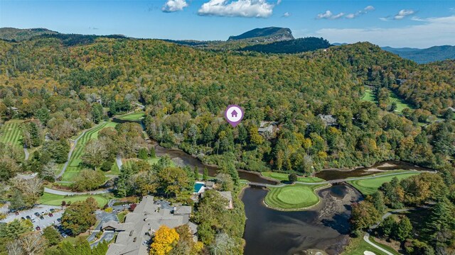 birds eye view of property featuring a mountain view, a wooded view, and view of golf course